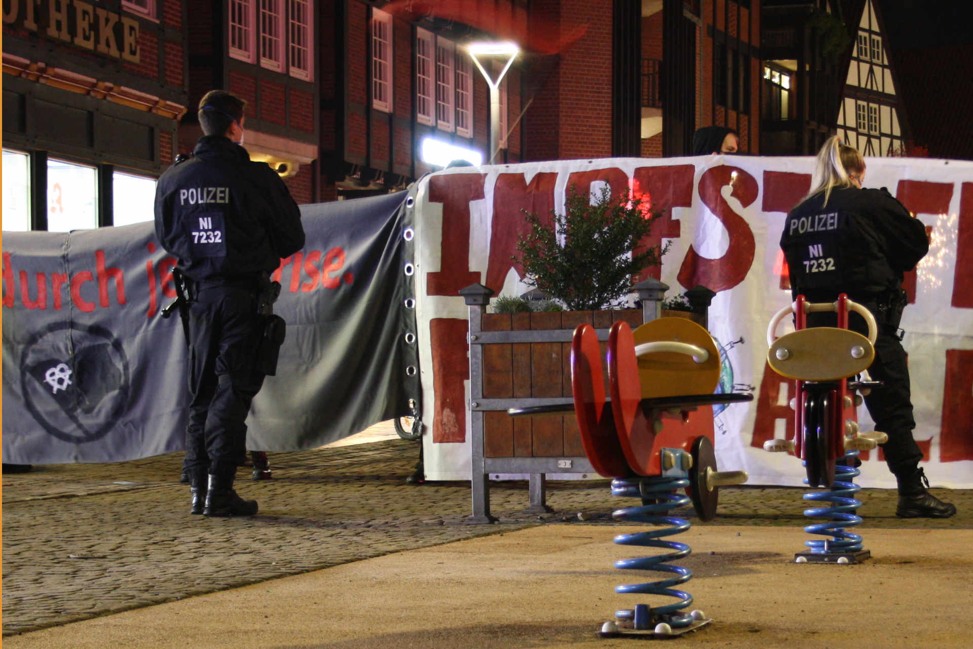Polizei vor Demonstrationstransparenten